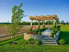 an outdoor patio with stone steps and seating area, surrounded by green grass and trees