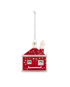 a red and white house ornament hanging from a wire on a white background