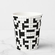 a paper cup with black and white crosswords on it