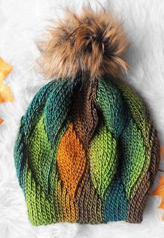 a multicolored knitted hat with a pom - pom on top