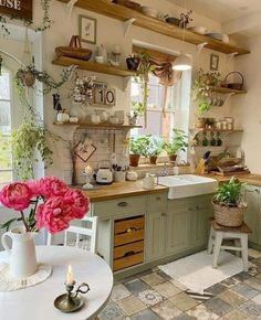 a kitchen filled with lots of counter top space and flowers on the windowsills