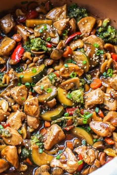 chicken, broccoli and peppers in a skillet on a wooden counter top