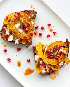 two pieces of bread with fruit and cheese on them, sitting on a white plate