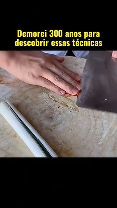 a person using a knife to cut up a piece of wood on top of a table