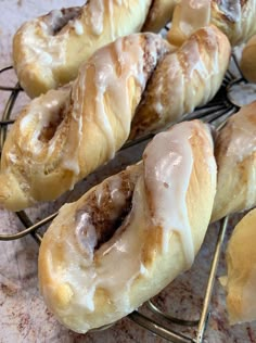 several doughnuts are cooling on a wire rack