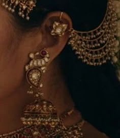 a close up shot of a woman's face with jewelry on her neck and ear