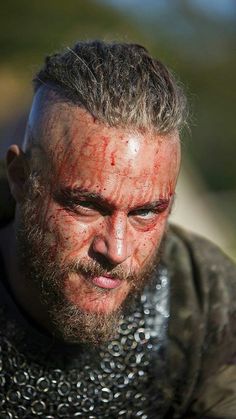 a close up of a man with a goatee on his head looking at the camera