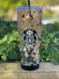 the starbucks cup is decorated with butterflies and glitters, as well as a straw