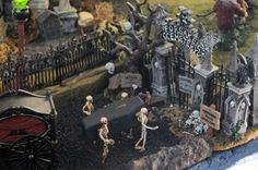 there is a fake graveyard with skeletons and tombstones on the ground in front of it