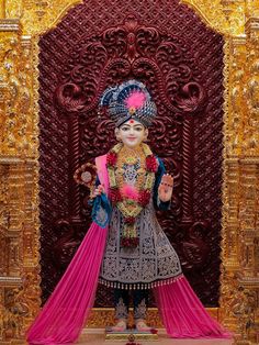 a statue in front of a red and gold wall