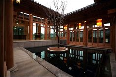 an indoor pool in the middle of a building with lots of windows on each side