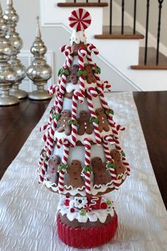 a christmas tree made out of cookies and candy canes on a table with stairs in the background