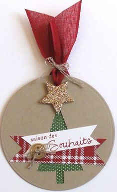 a christmas ornament hanging from a red ribbon on a white wall with the words salon de souhaist