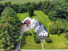 an aerial view of a large house surrounded by trees and grass in the country side