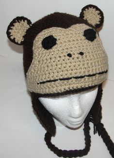 a crocheted monkey hat on a mannequin head