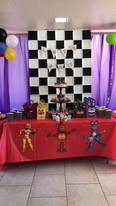 a table topped with cakes and cupcakes covered in paper art on top of a tiled floor