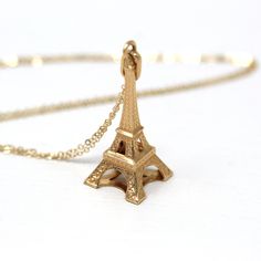 "Timeless modern circa 2000s era 14k yellow gold Eiffel Tower charm! This detailed figural charm is the shape of a miniature Eiffel Tower, and is shown modeled on a brand new 14k gold filled 18\" chain. This souvenir pendant would be a perfect gift for someone who loves Paris, France. A wonderful piece of fine modern jewelry, featuring the \"La dame de fer\"!  ERA - Circa 2000s - Estate METAL / MATERIAL - 14k yellow gold pendant, 14k gold filled chain MARKINGS / HISTORY - There are no markings, but this piece has been professionally tested.  CONDITION - Good condition. Yellow gold metal has been professionally polished & cleaned. Amazing modern Eiffel Tower charm!  SIZE / MEASUREMENTS - Chain Modeled: 18 inches, Pendant (including bail): 1 1/2 x 1/2 inches, Weight: 2.08 grams PRESENTATION: Eiffel Tower Gold Necklace, Gold Eiffel Tower, Paris Souvenirs, 2000s Era, Logo Gifts, Modern Necklaces, Yellow Gold Pendants, Metal Material, Modern Jewelry