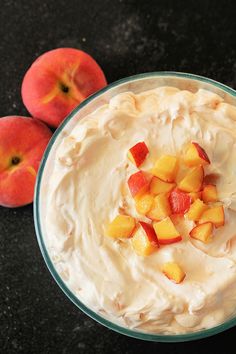 two peaches and some whipped cream in a bowl