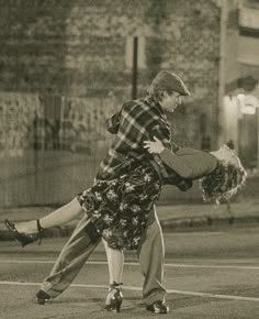 a man and woman are dancing on the street