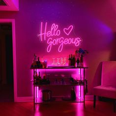 a bar with neon lights and bottles on the shelf in front of it that says hello gorgeous