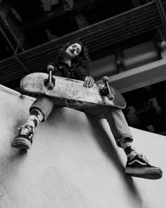 a man riding a skateboard up the side of a cement wall at a skate park