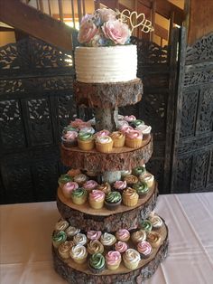 a three tiered cake with cupcakes on it