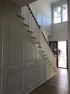 an empty room with stairs and hard wood flooring on the side of the wall