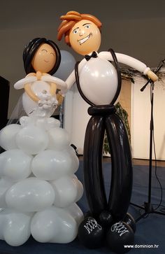 a bride and groom balloon sculpture next to an air - filled wedding cake topper