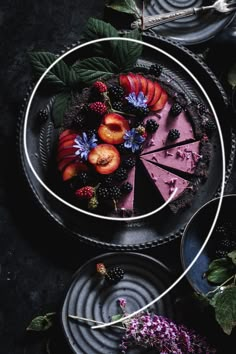 there is a pie with fruit on the top and flowers around it, along with other desserts