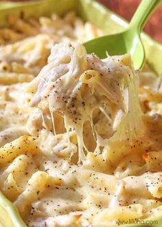 a spoonful of macaroni and cheese being lifted from a casserole dish