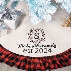 a personalized christmas tree skirt with the family name on it and presents under them