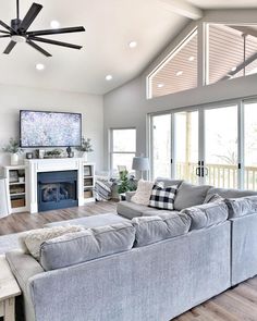 a living room filled with furniture and a flat screen tv mounted on the wall above a fireplace