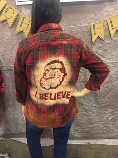 a woman standing in front of a wall wearing a red and black flannel shirt