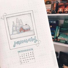 an open notebook with a drawing of a house on it