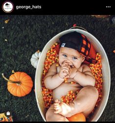 a baby sitting in a bucket with candy corn