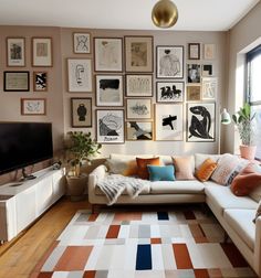 a living room filled with furniture and lots of pictures on the wall above it's tv