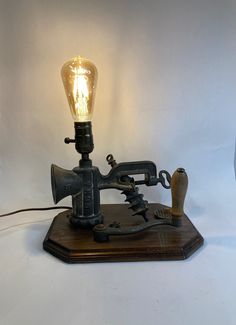 a light that is on top of a wooden stand with a lamp in the shape of a machine