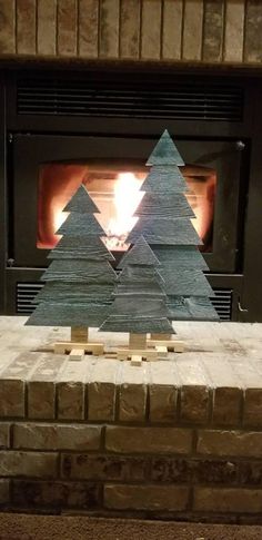 a fireplace with a small christmas tree made out of wood and some sort of paper