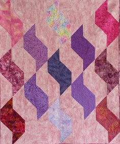 a pink and purple quilt with an abstract design