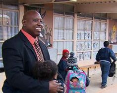 a man in a suit and tie holding a small child while standing next to other people