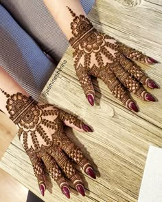 two hands with henna designs on them