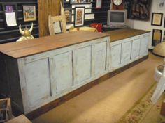 an old wooden counter in a room with pictures on the wall