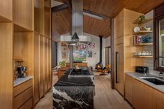 a kitchen with wooden cabinets and black marble counter tops, along with an island in the middle