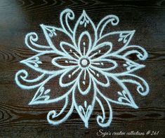 a wooden table with white paint on it and a flower design painted on the top