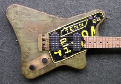 an old, worn out guitar sits on the ground