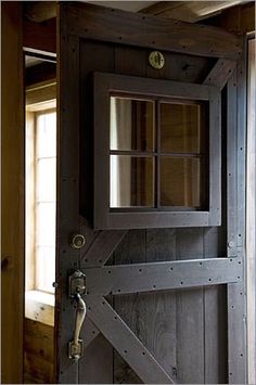 an open wooden door in a room with wood paneling and glass panels on the doors