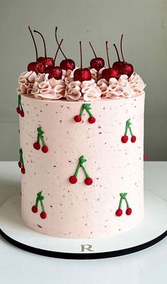 a cake decorated with cherries and pink frosting