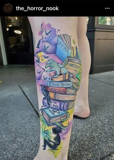 a woman's leg with books on it and her legs covered in watercolor