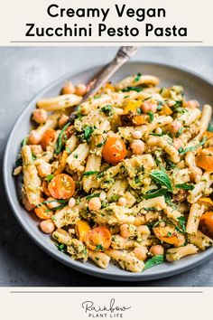 creamy vegan zucchini pesto pasta with carrots and spinach in a bowl