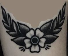 a black and white photo of a flower on the side of a woman's leg